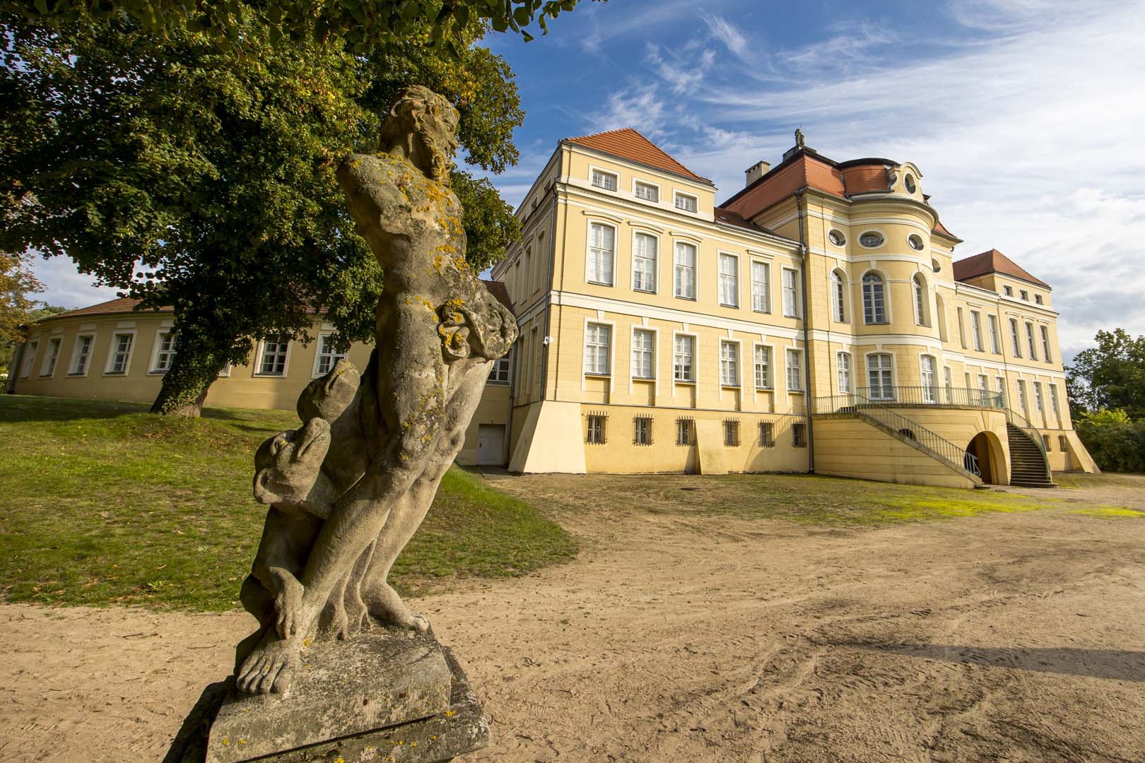 Pałac w Rogalinie od strony ogrodu z barokową rzeźbą na pierwszym planie